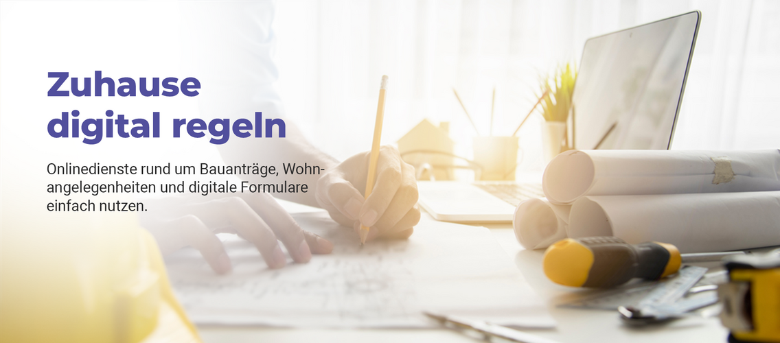 Bauplaner zeichnet an einer Skizze, daneben liegen Baupläne, Laptop und weitere Werkzeuge