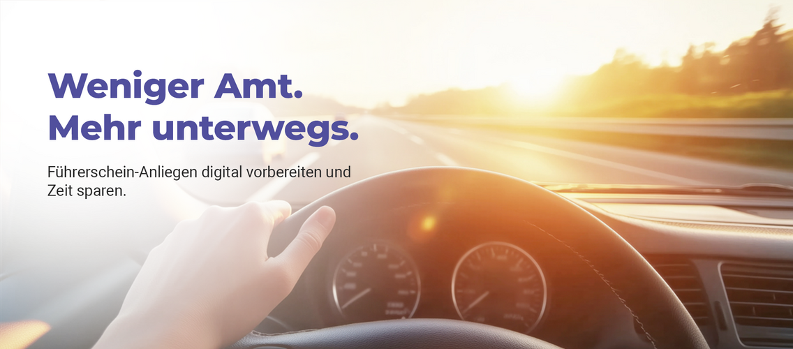 Person sitzt im Auto. Man sieht das Cockpit und schaut auf die Straße.